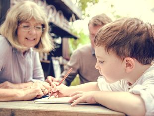 Grandmother helping child with writing.